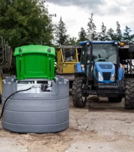 Ein Traktor auf einem Bauhof wird aus einer stationären Tankanlage betankt